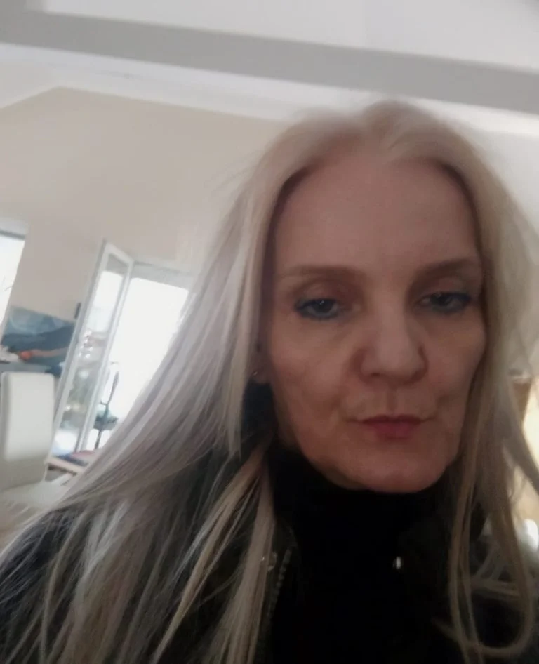 kobieta w czarnym golfie i długich blond włosach