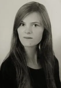 a head and shoulders shot of a young woman with long hair looking intently at the camera